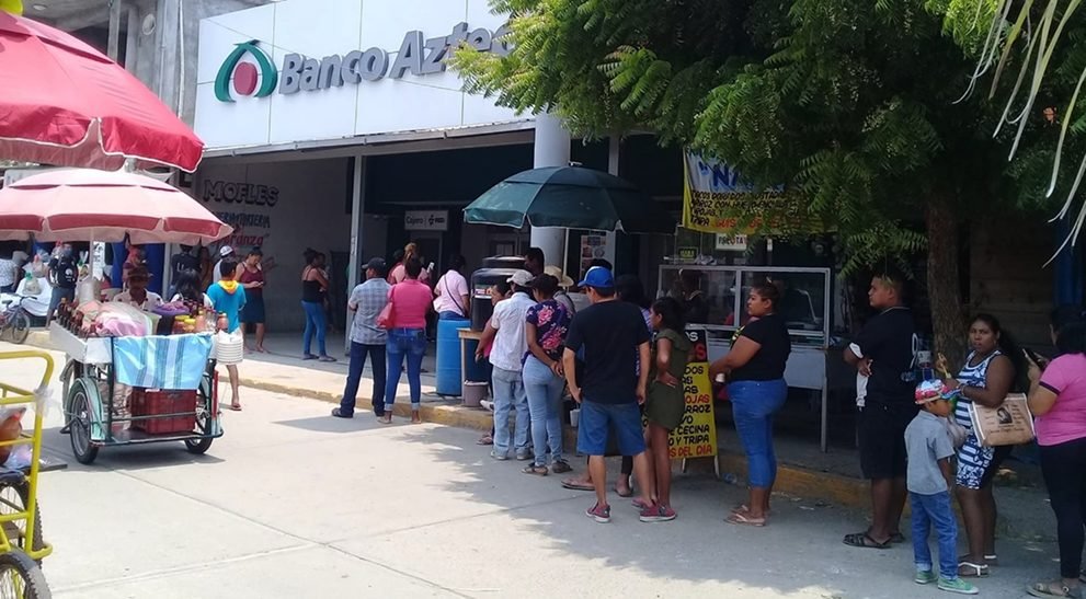 Sucursal de Banco Azteca con fila de clientes y comercio informal alrededor